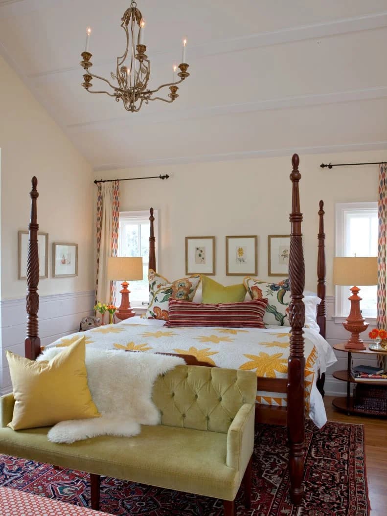 Schlafzimmer mit dunklem Himmelbett aus Holz, geblümter Bettwäsche und gerahmten Bildern
